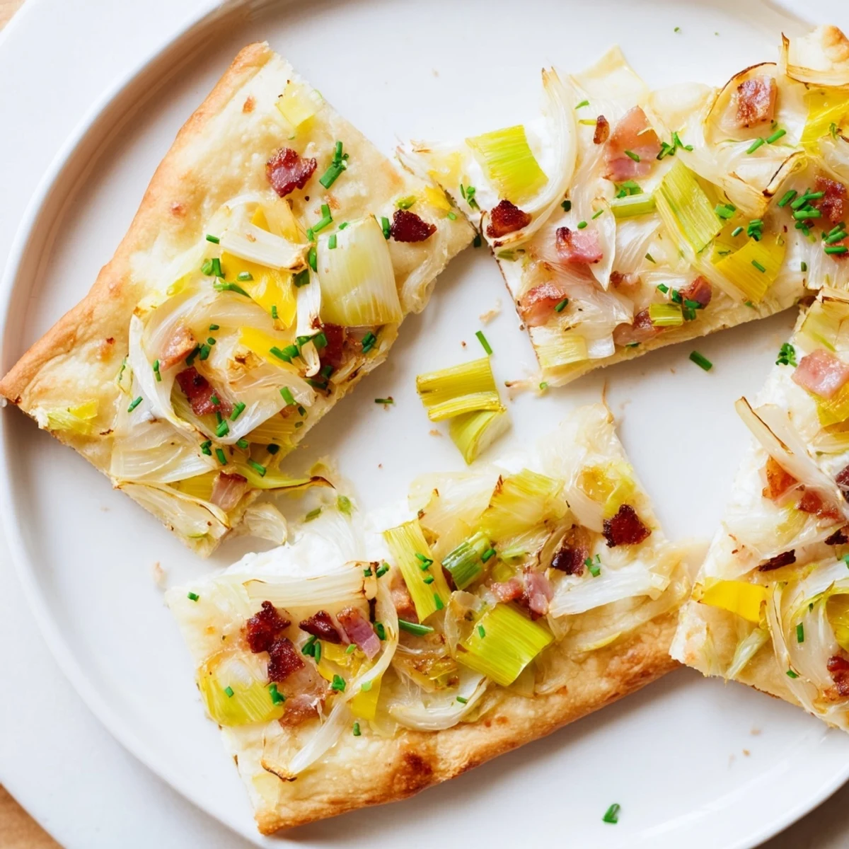 Sheet-Pan Flammkuchen with golden, bubbly crust, topped with bacon and caramelized leeks.