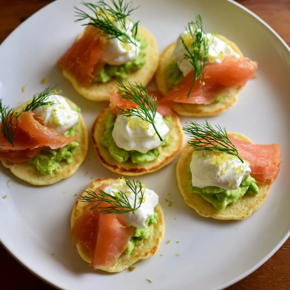 Quark blinis with smoked salmon, showing fluffy blinis topped with creamy avocado and salmon slices.