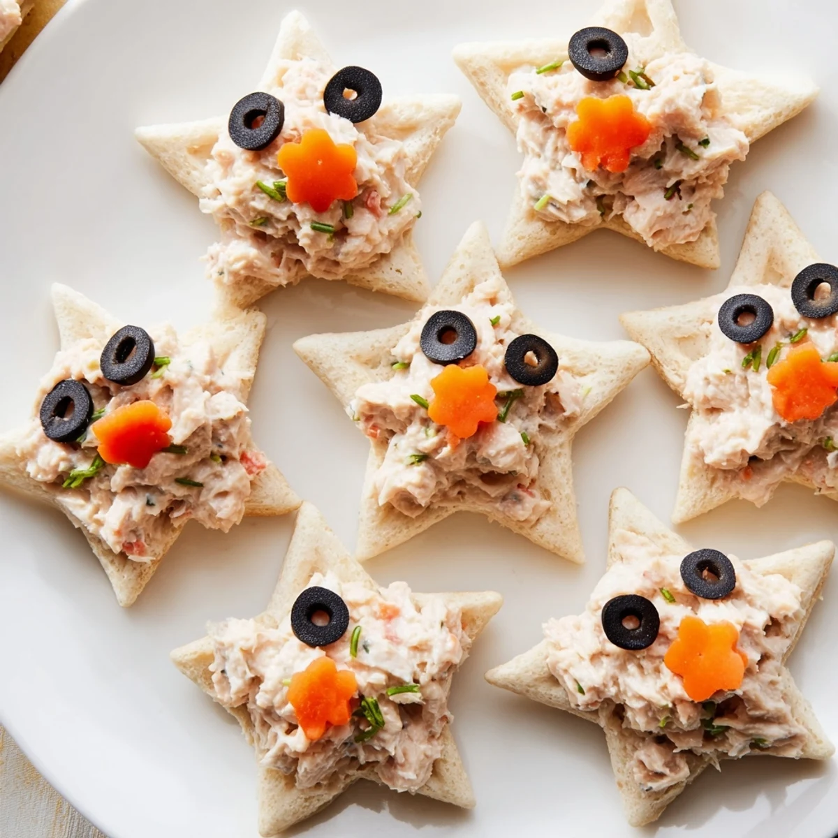 Mini Starfish Sandwiches: Cute tuna sandwiches with olive eyes and carrot star points, perfect for a children's party.