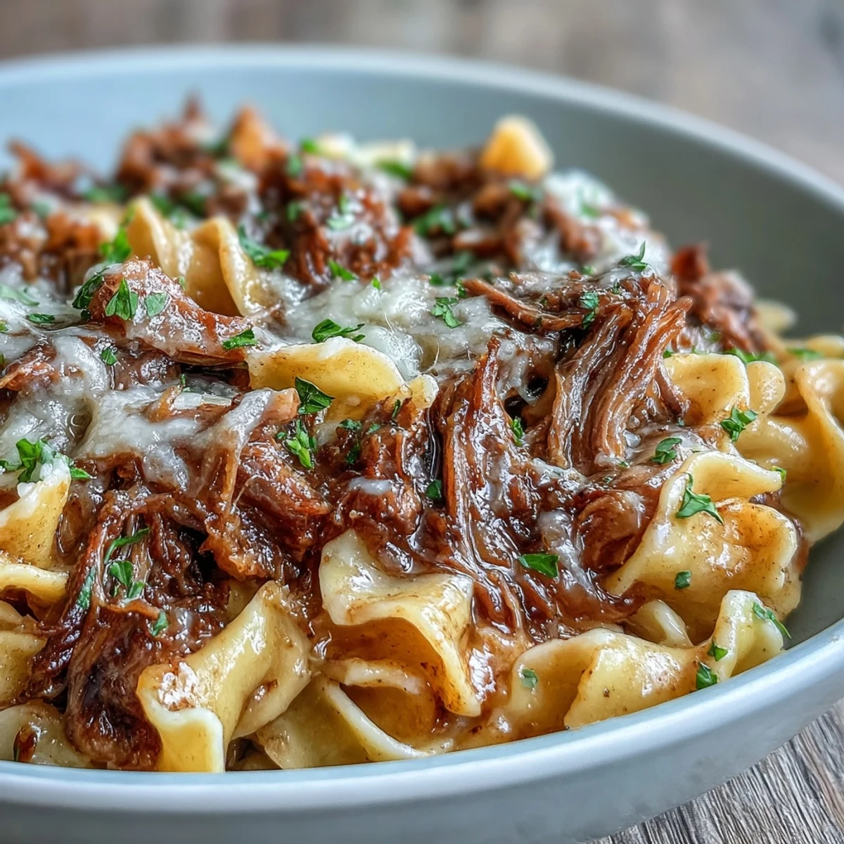 Crockpot French Onion Pot Roast Pasta mit Käse und frischer Petersilie garniert