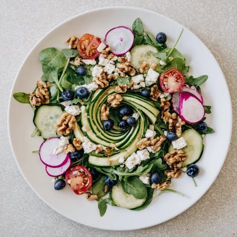 Vibrant Fibonacci Fan Salad with fresh greens, tomatoes, and creamy feta cheese, ready to serve.