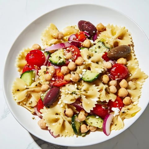Vibrant Mediterranean pasta salad with chickpeas, feta cheese, and fresh, colorful vegetables.