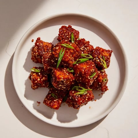 Crispy Honey Gochujang Tofu glistening in a sweet and spicy sauce, ready for serving.