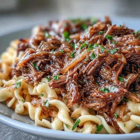Crockpot French Onion Pot Roast Pasta mit zartem Rindfleisch, butterigen Eiernudeln und würziger Zwiebelsoße.