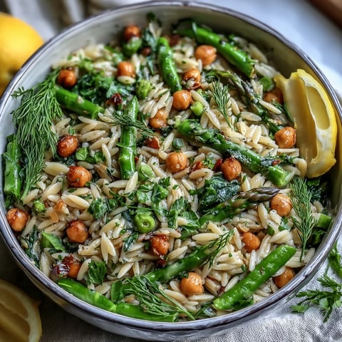 Eine farbenfrohe Pfanne mit Zitronen-Orzo, Kichererbsen und knackigem Frühlingsgemüse.