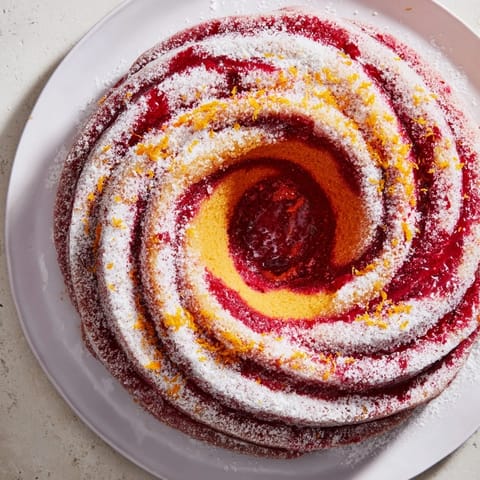 Festive The Cranberry Orange Swirl cake, featuring a beautiful spiral and sweet-tart flavors.