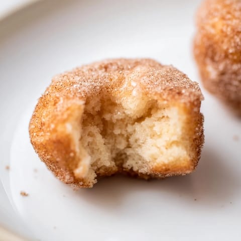 Warm, golden air fryer cinnamon donuts, offering a delightful combination of textures and flavors.