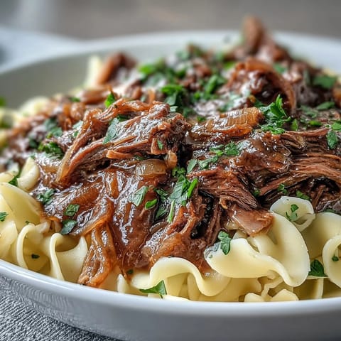 In diesem Crockpot French Onion Pot Roast Pasta garen Rindfleisch und Zwiebeln wochenlangsam zur perfekten Mahlzeit.