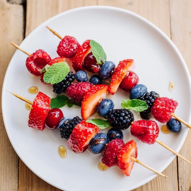 Bright red strawberries and juicy blueberries on refreshing fruit skewers, ready to eat.