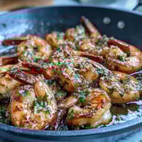 1. Knoblauchbutter-Garnelen in einer siedend heißen Pfanne, goldbraun gebraten und mit frischer Zitronensauce glänzend.  